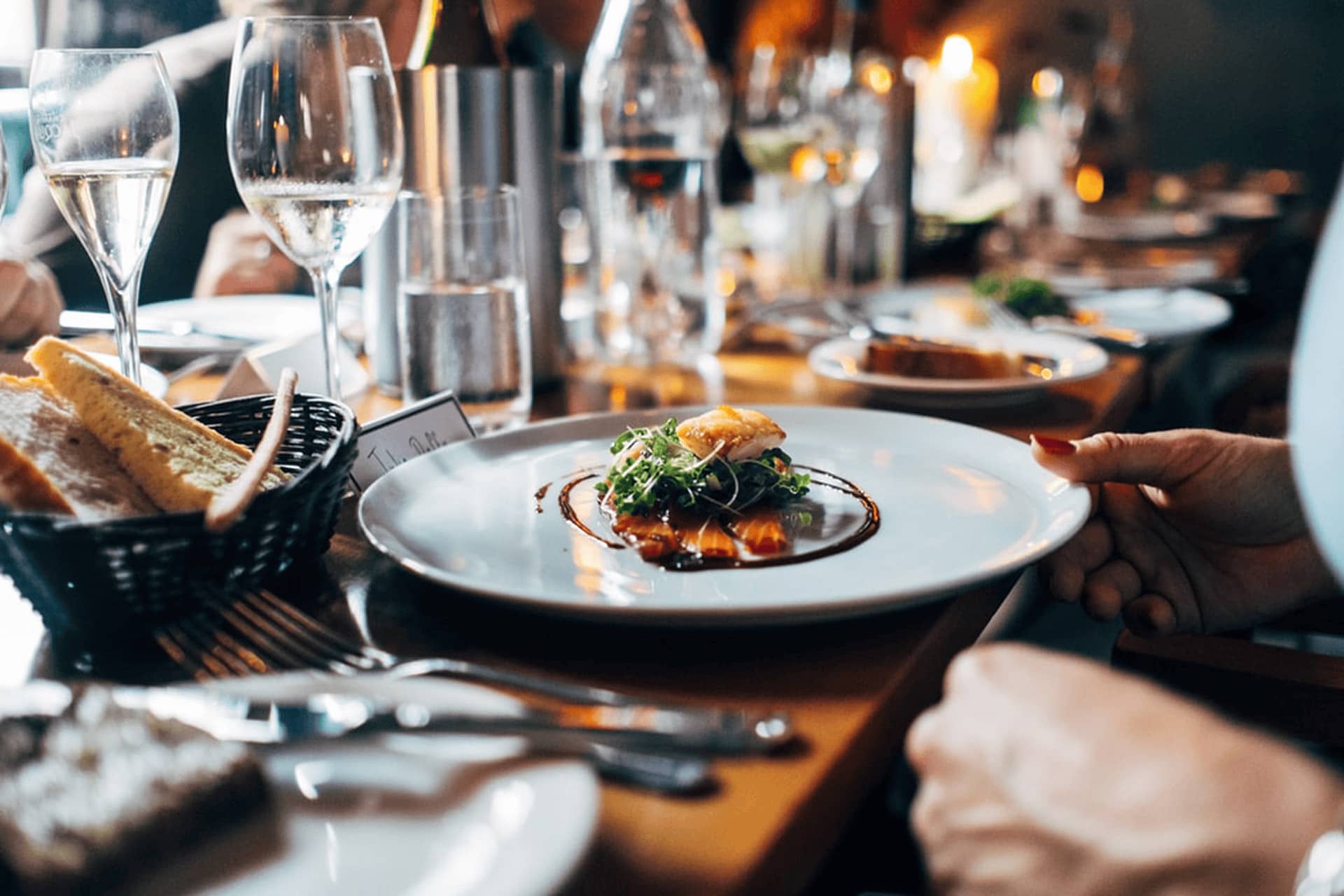 Elegant gedeckter Restauranttisch mit Fine-Dining-Gericht und Weingläsern